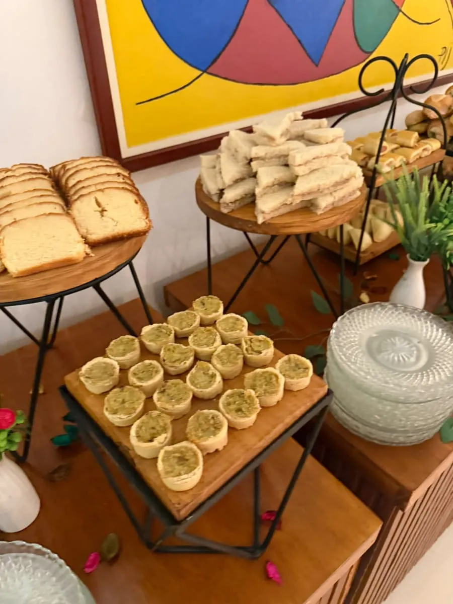 Mini tortinhas, sanduíches e fatias de bolo em expositores de madeira — evento corporativo do Buffet Big House
